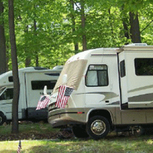Two rvs parked in a wooded area.