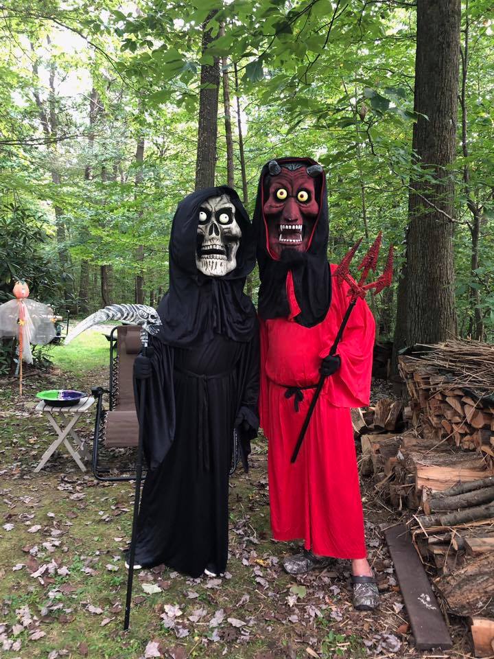 Two people dressed as demons in a wooded area.