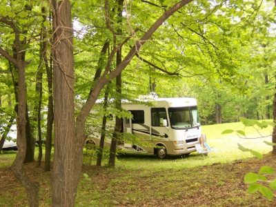 An rv parked in a wooded area.